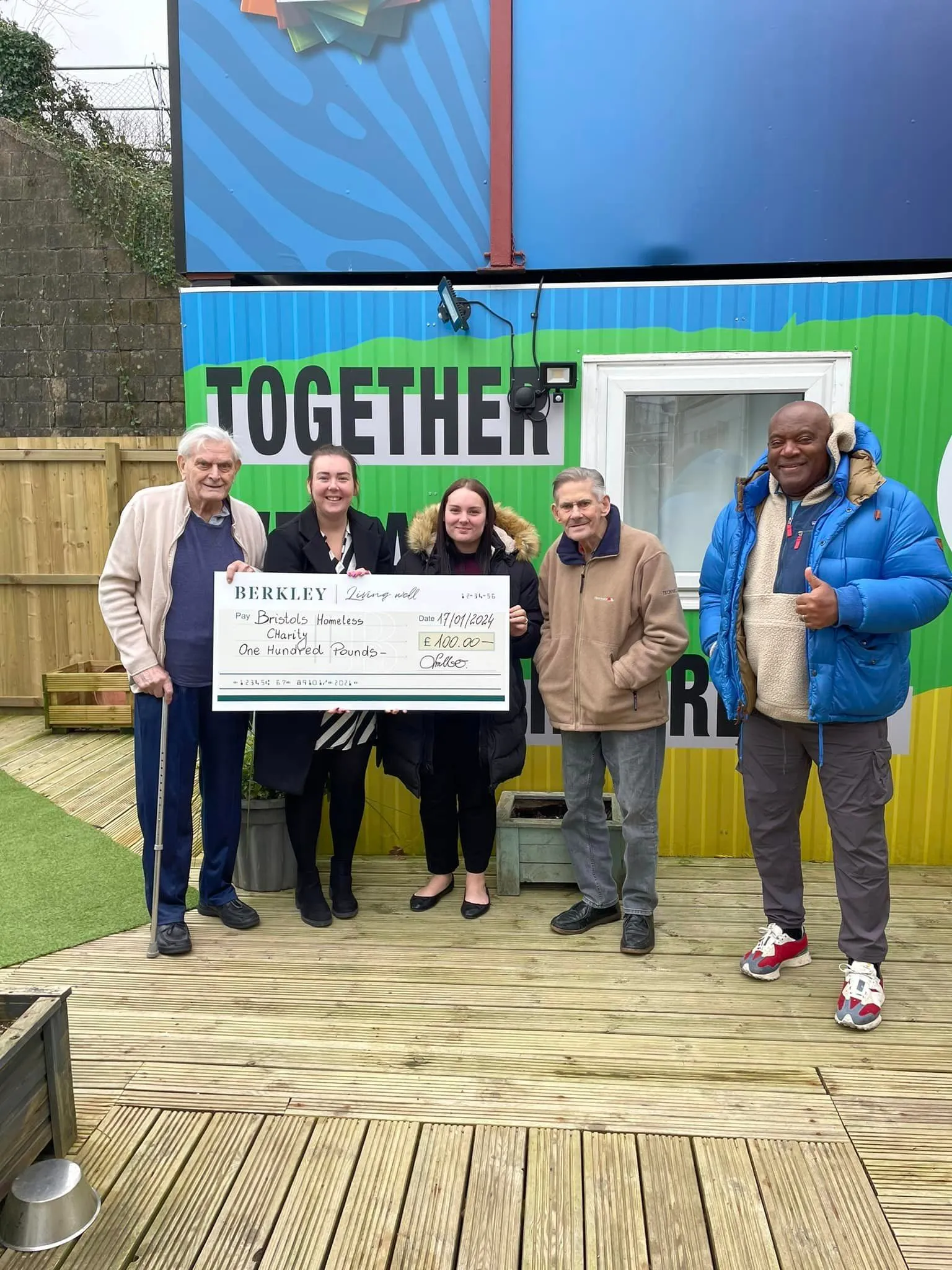 group holding up check going to charity