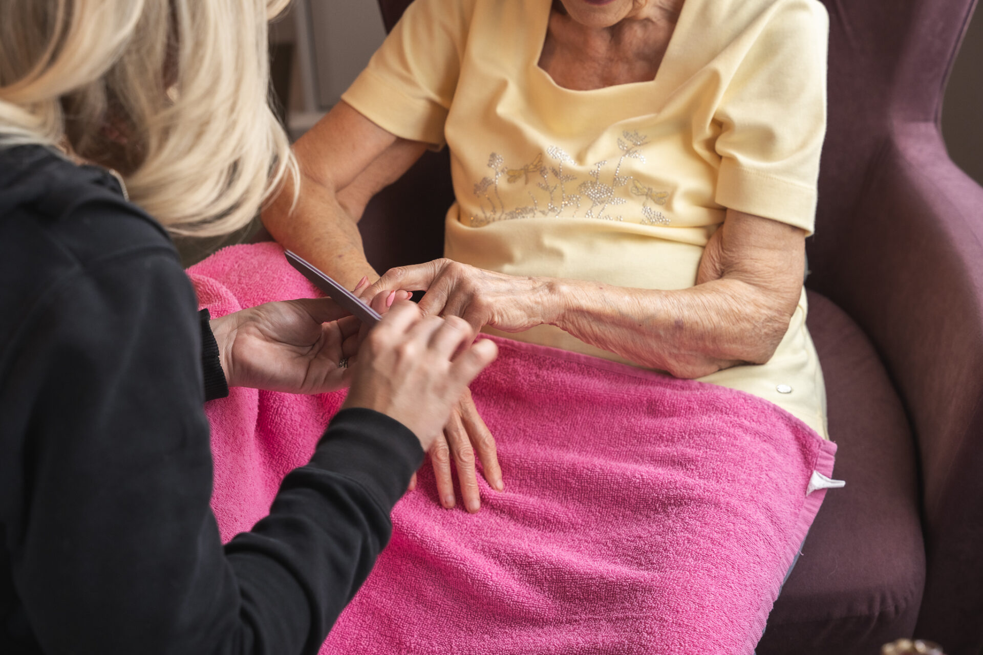 A guest having her nails done in an armchair at a Berkley care home
